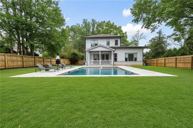 a front view of a house with garden and swimming pool