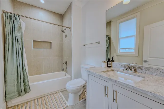 a bathroom with a granite countertop sink a toilet and shower