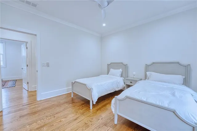 a bedroom with two beds and wooden floor