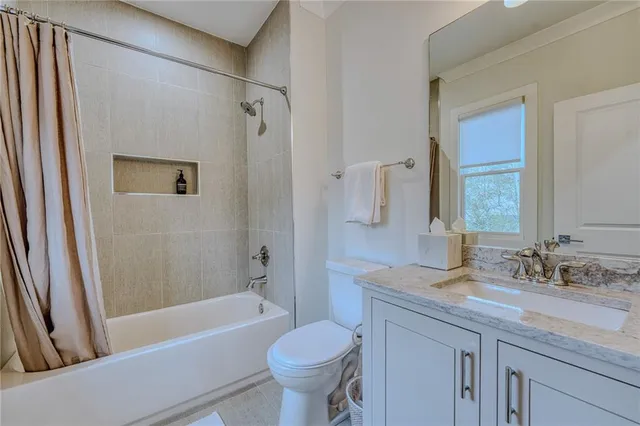 a bathroom with a granite countertop toilet sink and bathtub