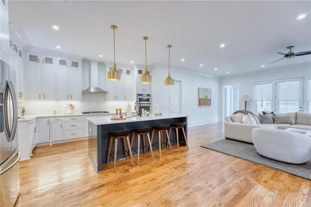 a large kitchen with kitchen island a sink a center island stainless steel appliances and a window