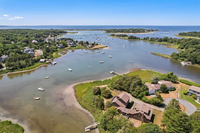 an aerial view of ocean and residential houses with outdoor space