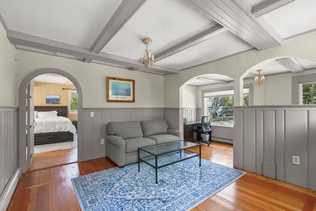 a view of a hallway with wooden floor and dining room