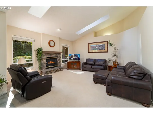 a living room with furniture a large window and a fireplace