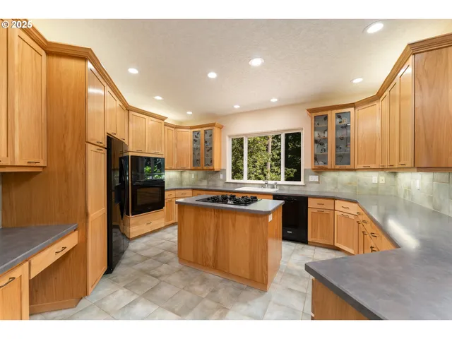 a kitchen with stainless steel appliances granite countertop sink stove top oven and refrigerator