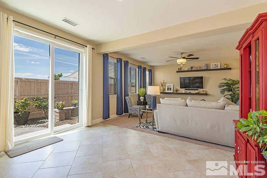 10171 Quintana Drive Reno, NV 89521 - Photo 11 of 25 a living room with furniture a dining table kitchen view and large windows