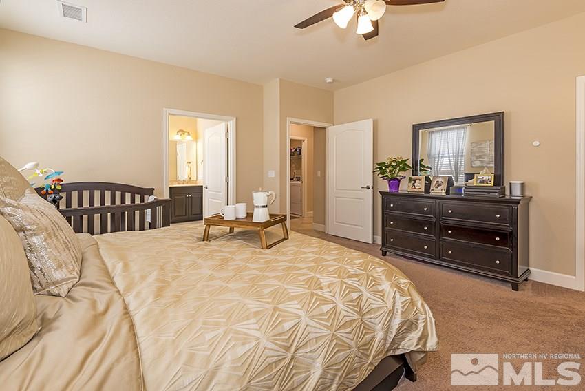 10171 Quintana Drive Reno, NV 89521 - Photo 14 of 25 a bedroom with a bed and a chandelier