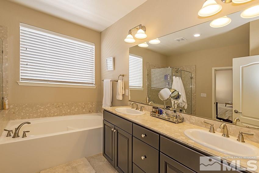 10171 Quintana Drive Reno, NV 89521 - Photo 15 of 25 a bathroom with a tub double sink and mirror