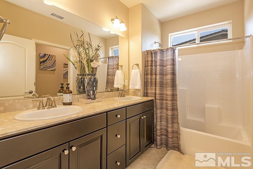 10171 Quintana Drive Reno, NV 89521 - Photo 19 of 25 a bathroom with a double vanity sink toilet mirror and shower