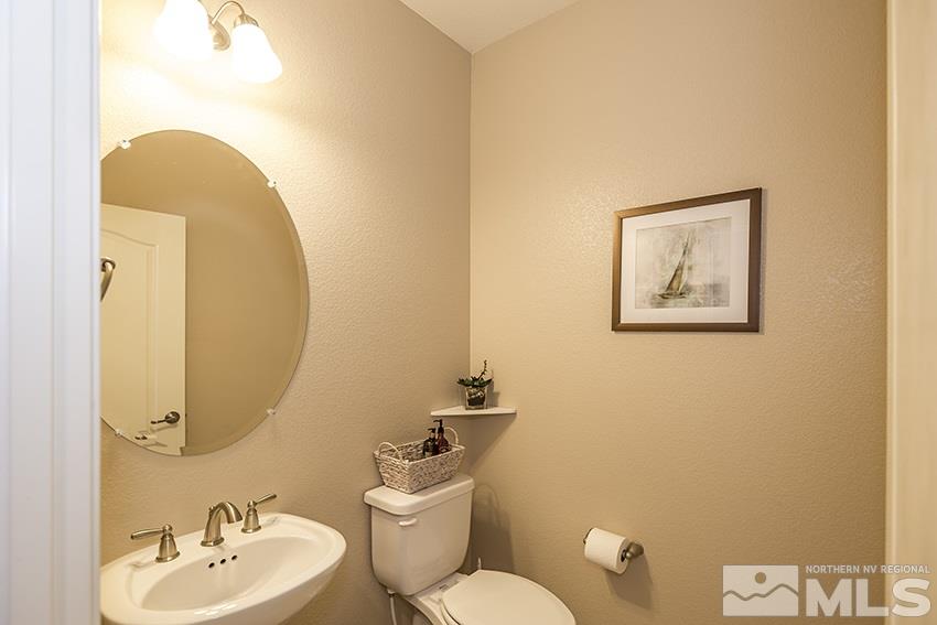 10171 Quintana Drive Reno, NV 89521 - Photo 22 of 25 a bathroom with a toilet a sink and mirror