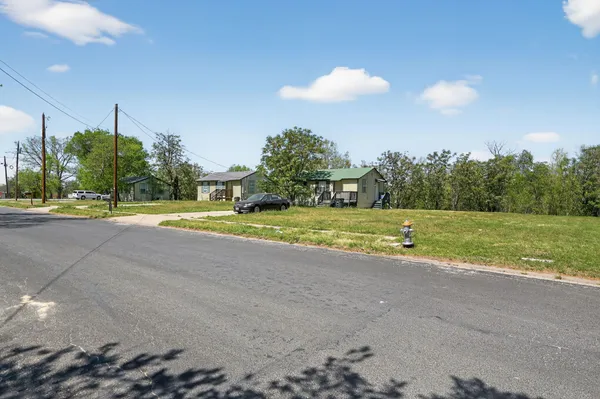a view of a fountain in front of a house with a big yard
