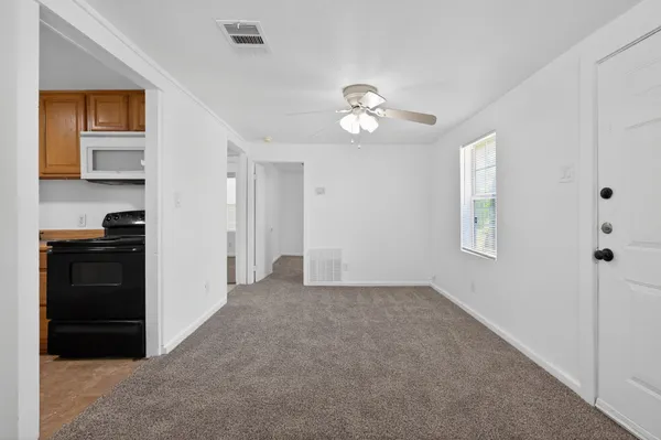 a view of a kitchen that has a fridge cabinets and a window