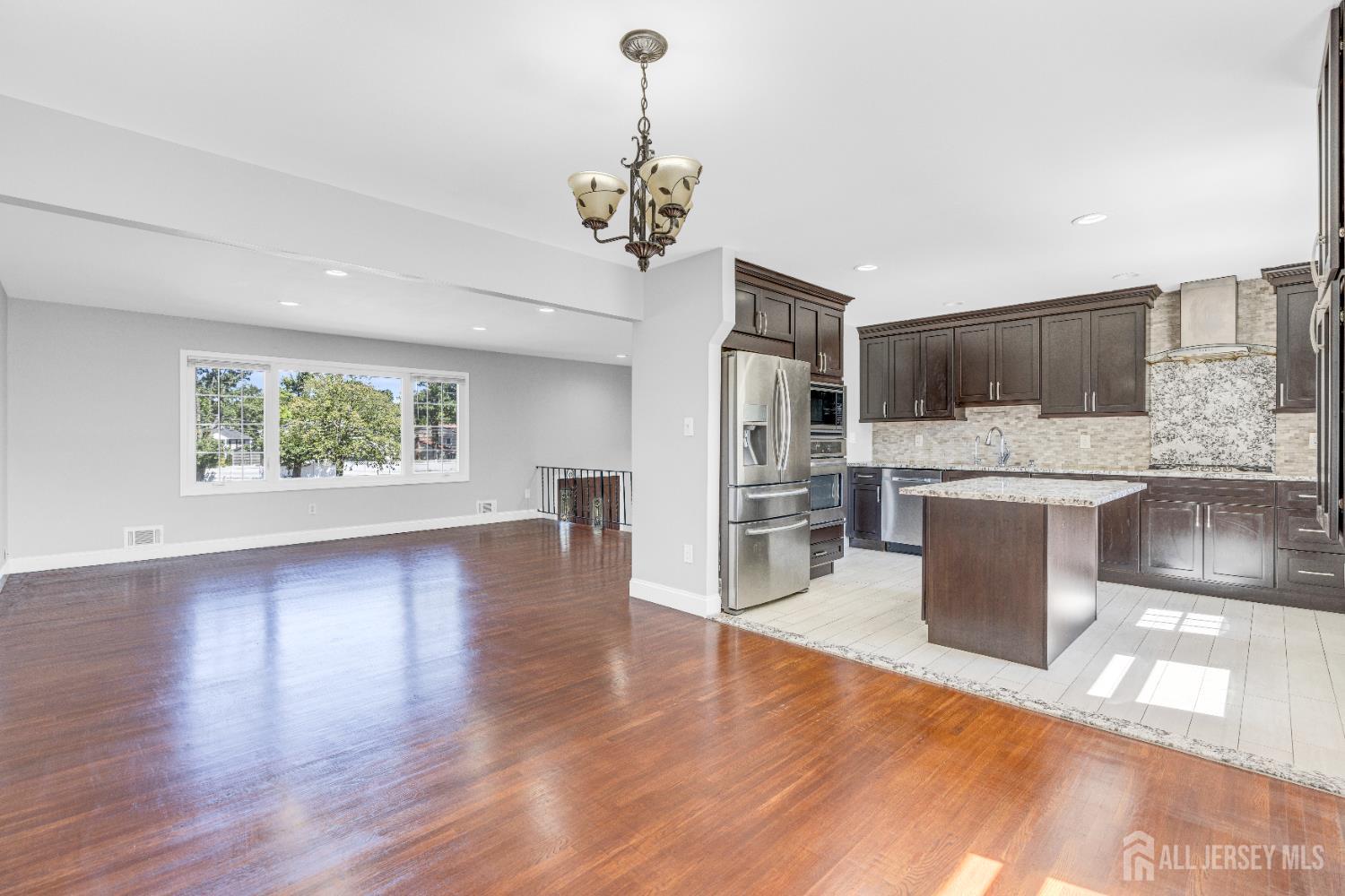 6 Marc Court Edison, NJ 08820 - Photo 15 of 42 a kitchen with stainless steel appliances granite countertop a refrigerator a oven a sink with wooden floors and cabinets