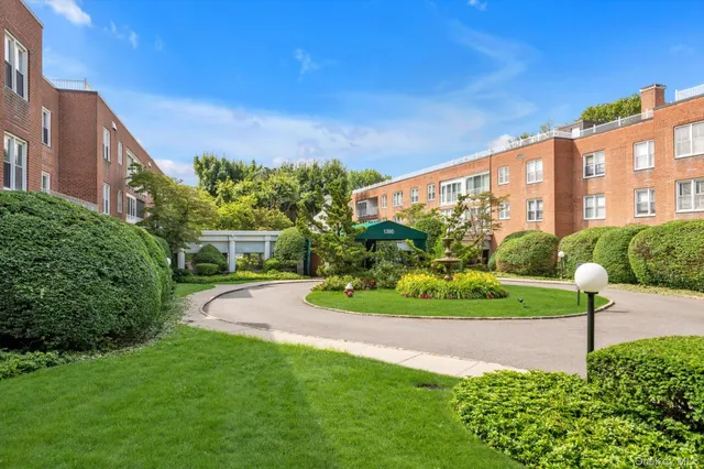 a view of a big house with a big yard and potted plants