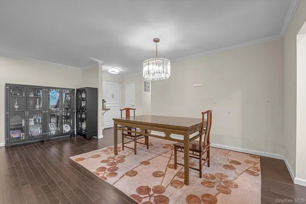 a dining room with wooden floor a chandelier a wooden table and chairs