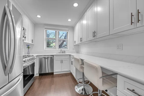 a kitchen with granite countertop white cabinets and white appliances