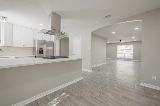 a view of a kitchen with a sink and dishwasher with wooden floor