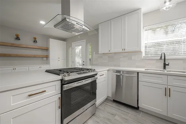 a kitchen with cabinets appliances and a window