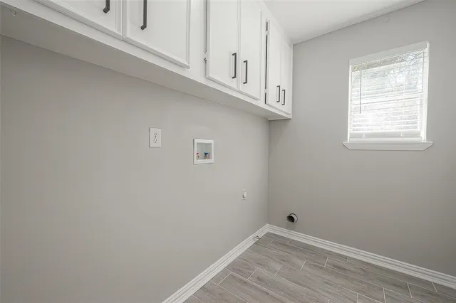 a view of an empty room with wooden floor and cabinet