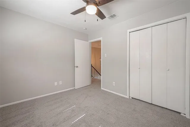 an empty room with chandelier fan