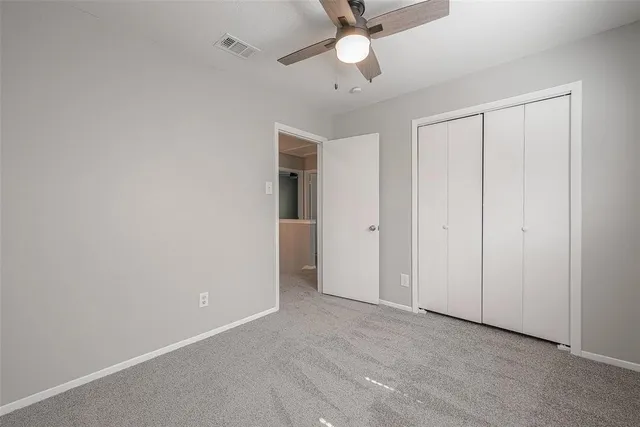 an empty room with a ceiling fan and a fan