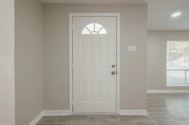 an empty room with wooden floor and a window