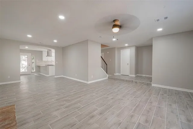 a view of empty room with wooden floor and window