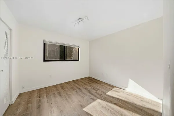 a view of a room with wooden floor and a ceiling fan