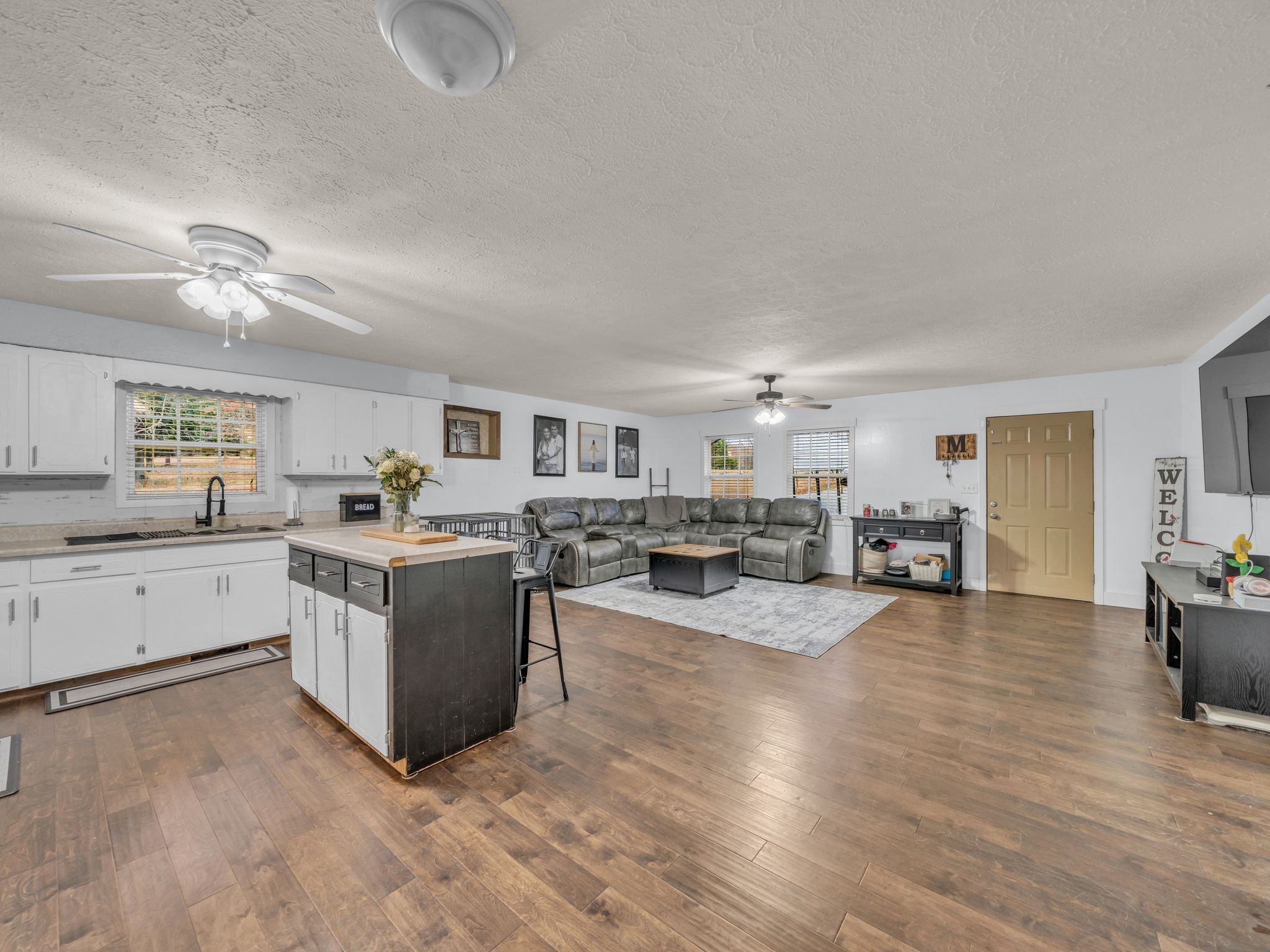 4055 Erin Road McEwen, TN 37101 - Photo 8 of 25 a large white open kitchen with cabinets a sink and dishwasher a stove with wooden floor