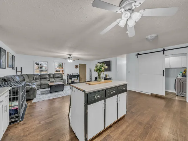 a view of living room with kitchen island furniture and ceiling fan