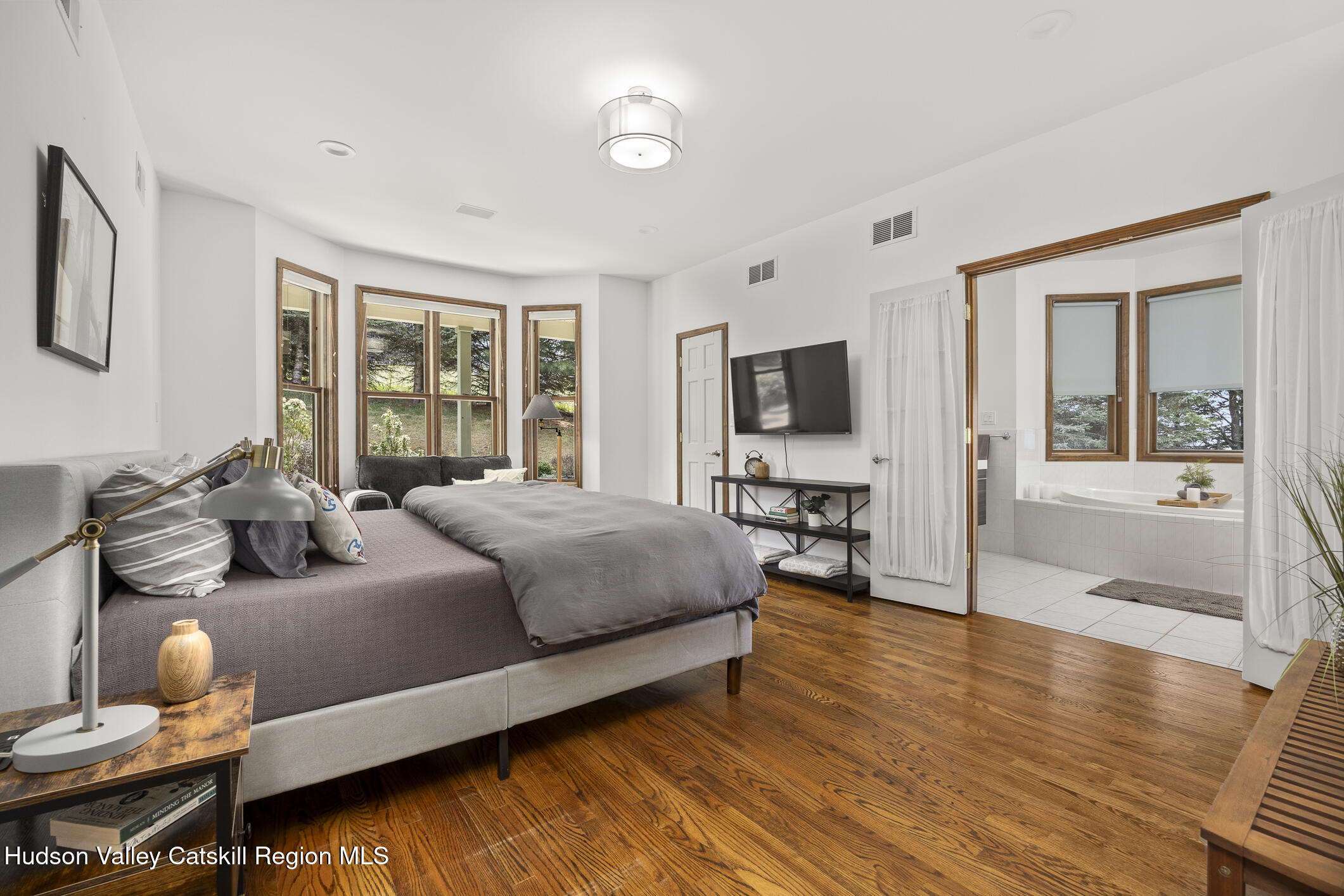 350 Taghkanic Road Elizaville, NY 12523 - Photo 17 of 36 a spacious bedroom with a bed and wooden floor
