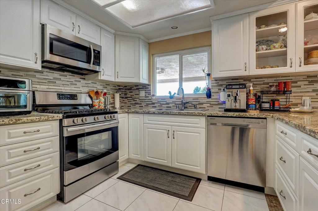 12477 Rajah Street Los Angeles, CA 91342 - Photo 16 of 34 a kitchen with stainless steel appliances granite countertop a stove microwave and cabinets