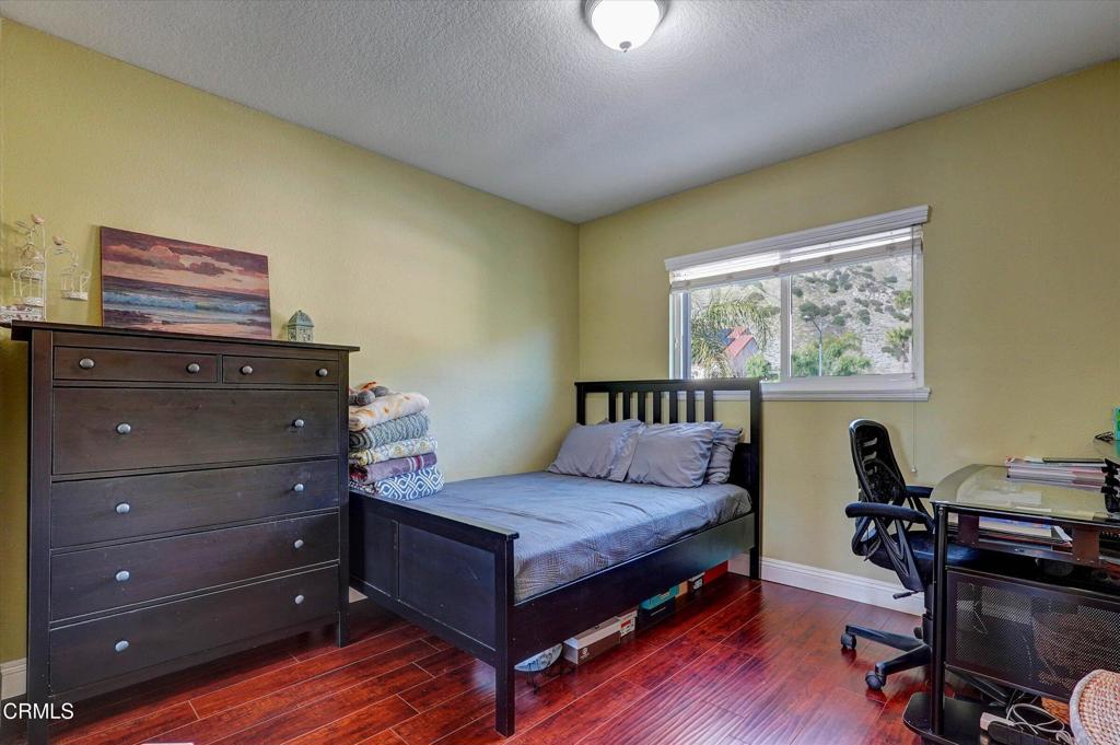 12477 Rajah Street Los Angeles, CA 91342 - Photo 32 of 34 a bedroom with a bed and wooden floor