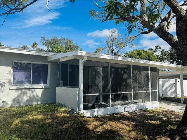 a view of a house with a large window and a yard with wooden fence