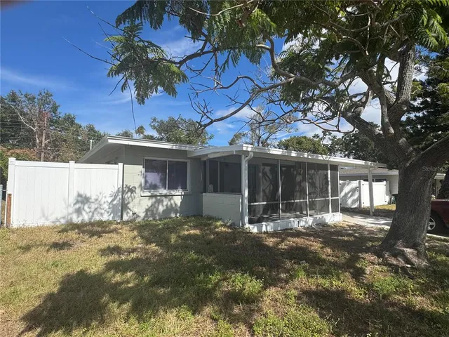 a kitchen with stainless steel appliances granite countertop a stove top oven a sink dishwasher and white cabinets with wooden floor