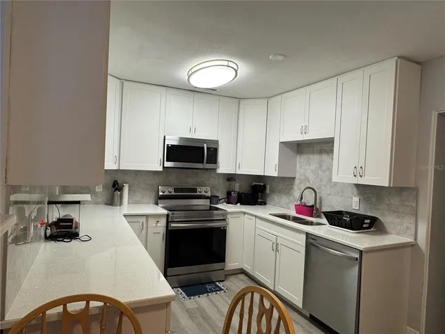 a kitchen with a sink a stove and cabinets