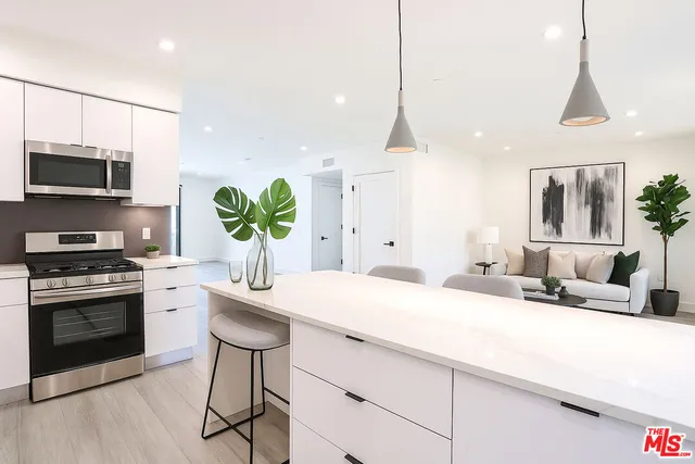 a kitchen with a sink a counter top space appliances and cabinets