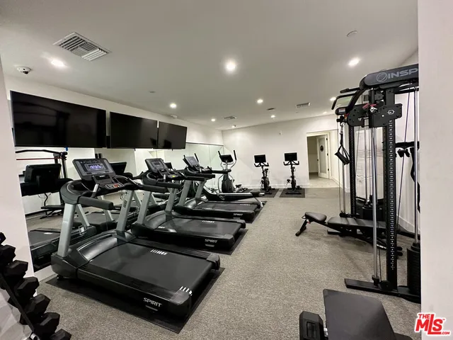 a room with gym equipment and a flat screen tv