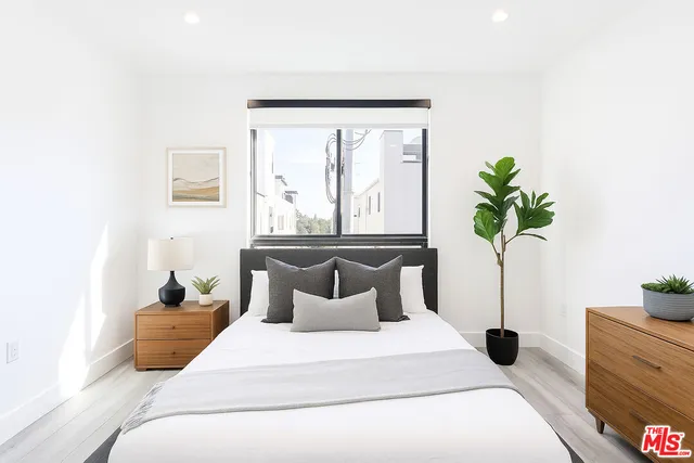 a bedroom with a bed and a potted plant