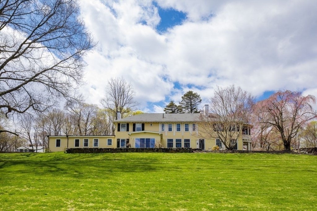 a view of a big yard with a house in the background