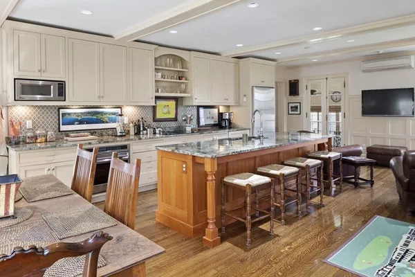 a large kitchen with stainless steel appliances granite countertop a stove a sink a dining table and chairs