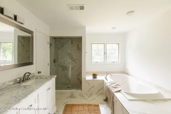 a bathroom with a granite countertop sink and a bathtub