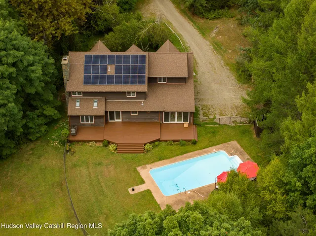 a view of a house with pool and a yard