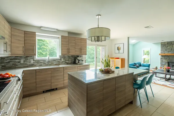 a kitchen with stainless steel appliances granite countertop a sink a stove and a wooden floors