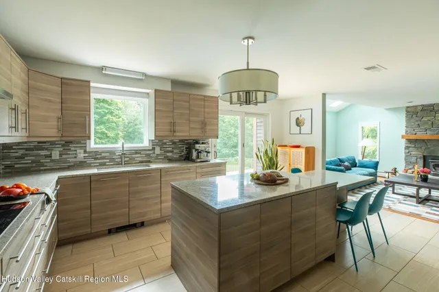 a kitchen with stainless steel appliances granite countertop a sink a stove and a wooden floors