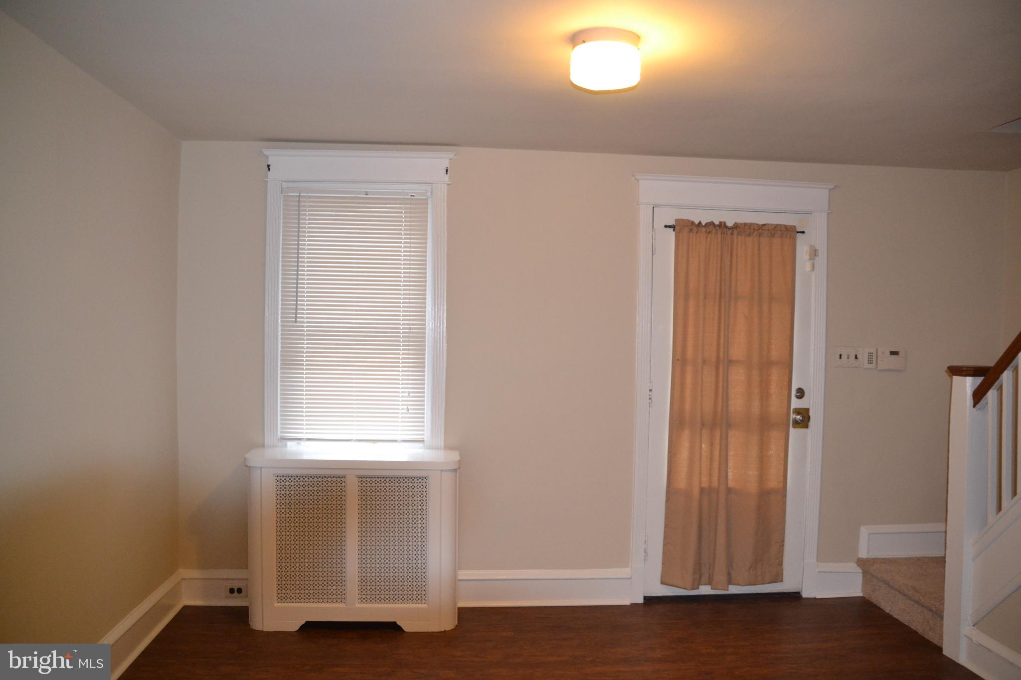 7042 Clinton Road Upper Darby, PA 19082 - Photo 13 of 33 a view of an empty room with wooden floor and a window