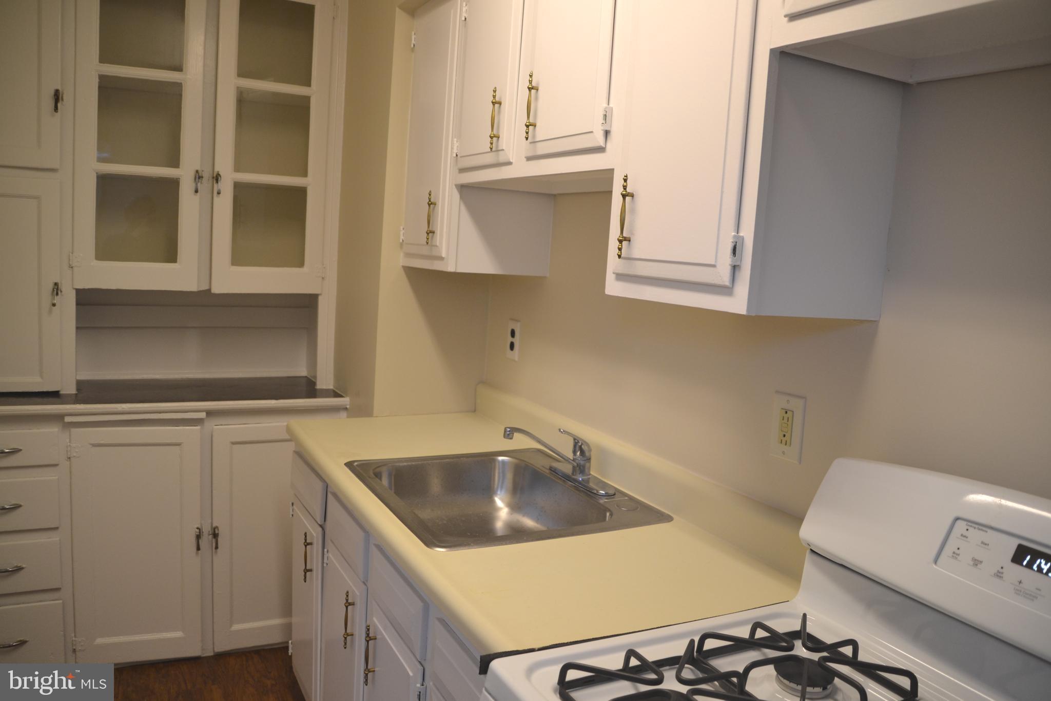 7042 Clinton Road Upper Darby, PA 19082 - Photo 18 of 33 a kitchen with a sink cabinets and a stove top oven