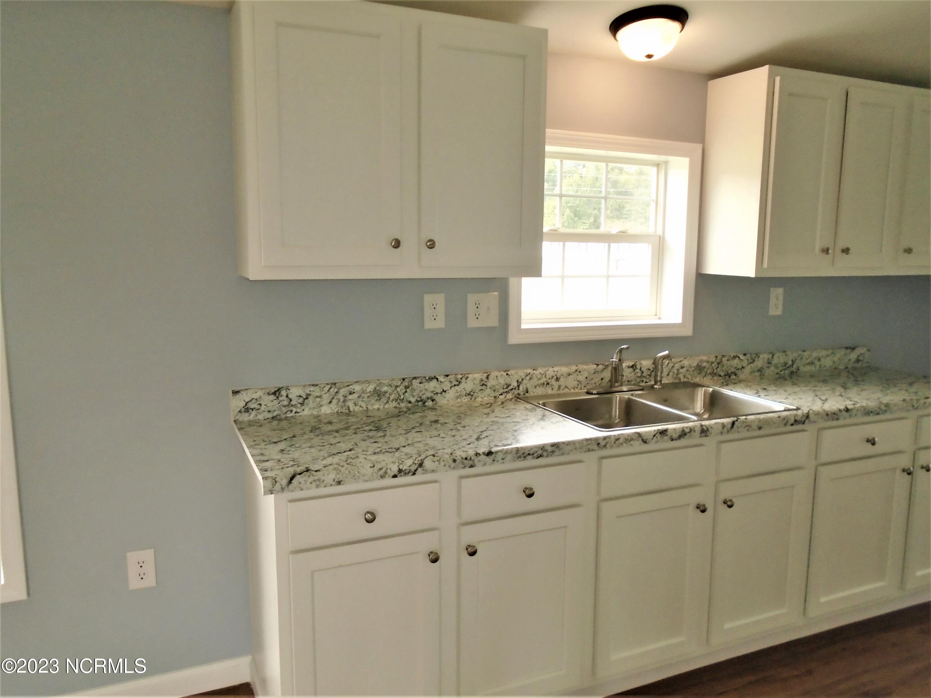 94 Sherlock Holmes Road Enfield, NC 27823 - Photo 8 of 26 Both sides of the kitchen counters are lined with cabinets top and bottom!