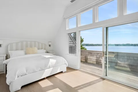 a bedroom with a bed and a large window