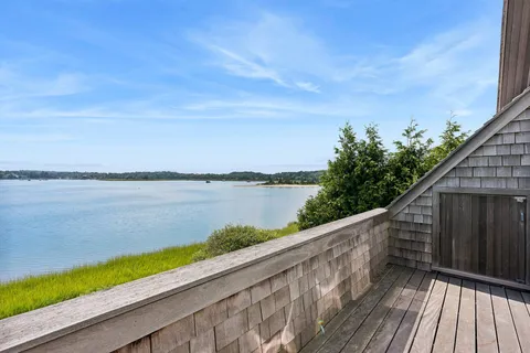 a view of balcony with wooden floor and lake view